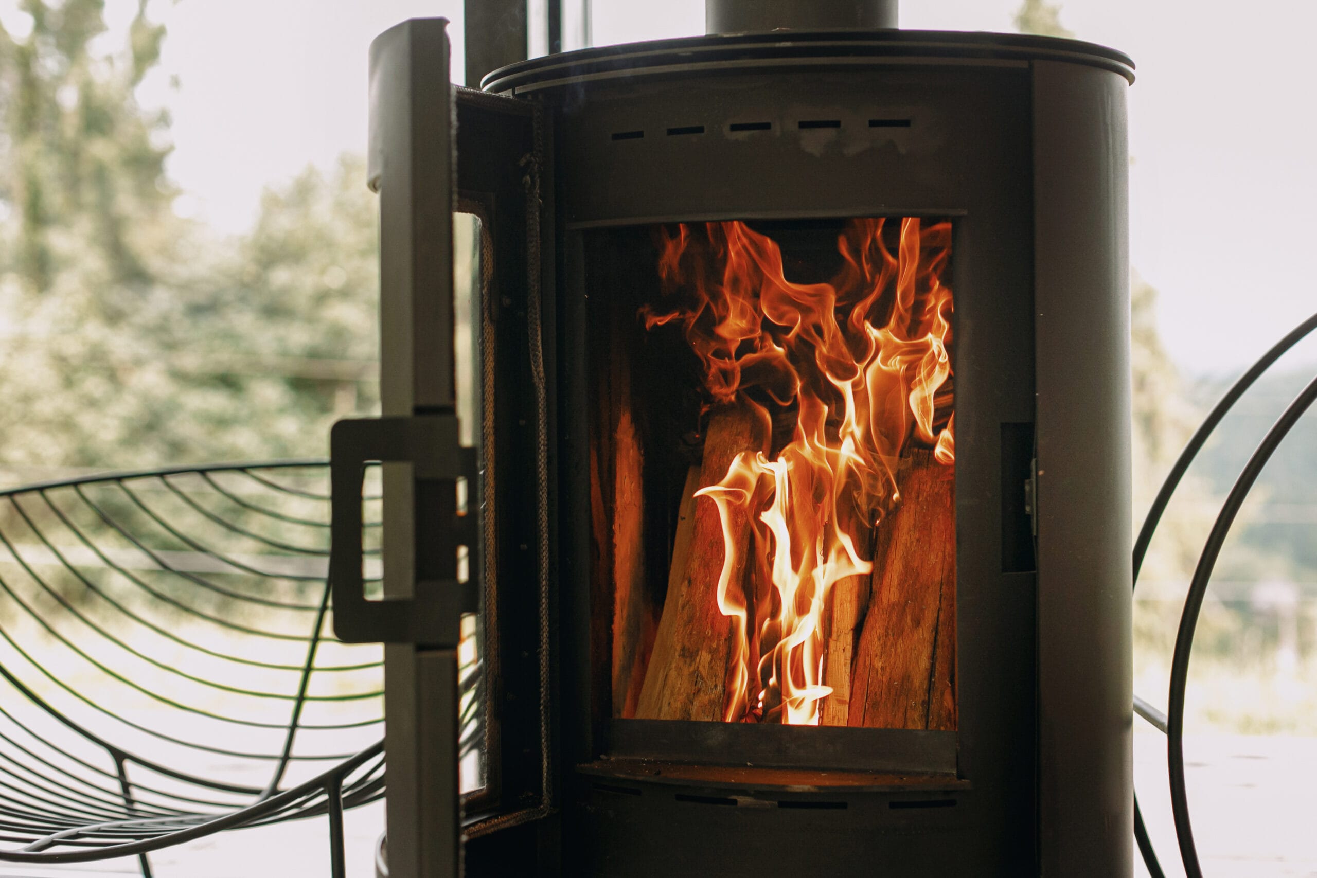 modern,black,fireplace,with,burning,fire,and,firewood,on,metal