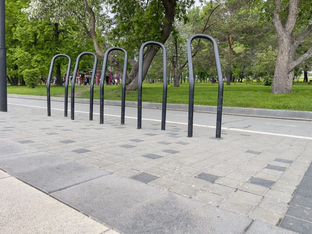 a,stainless,steel,bike,rack,in,a,public,park.