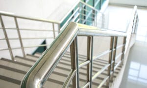 stainless,steel,handrail,and,white,stair,in,office,building