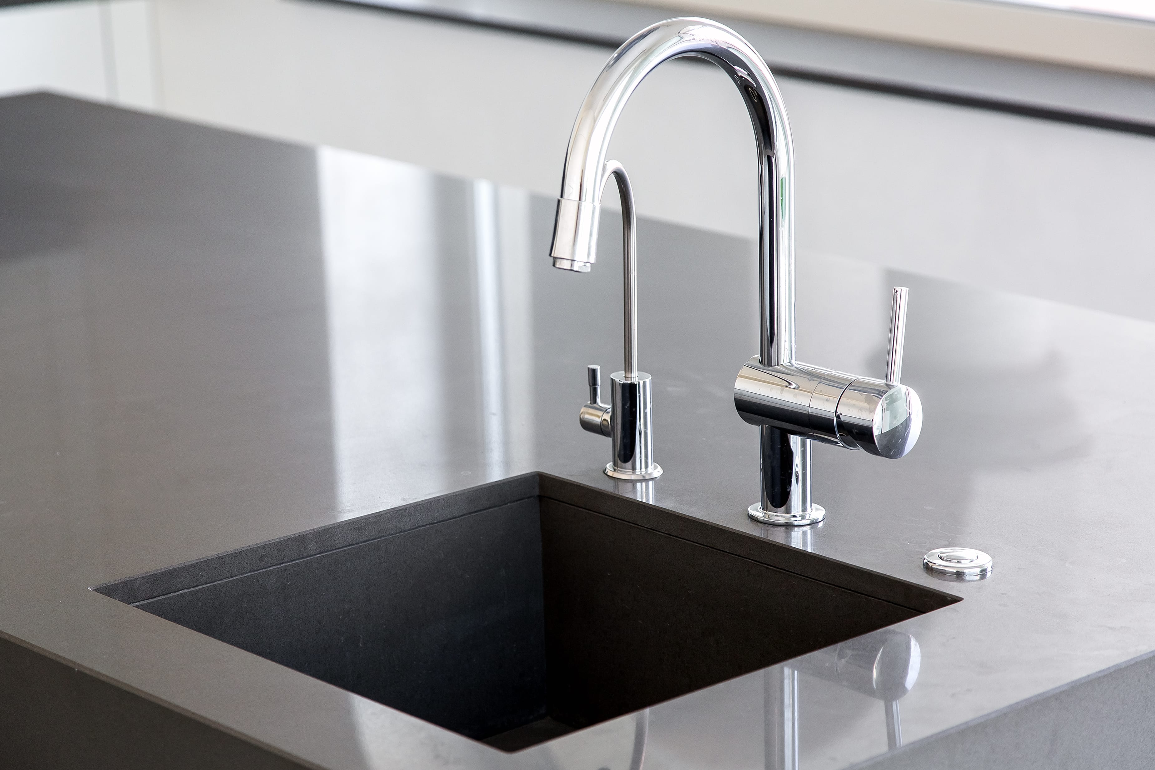 kitchen,sink,of,dark,gray,stone,with,chrome,faucet,in