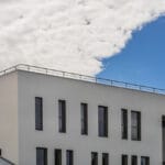 Bâtiment moderne avec toit plat et garde-toit servant de garde-corps en acier