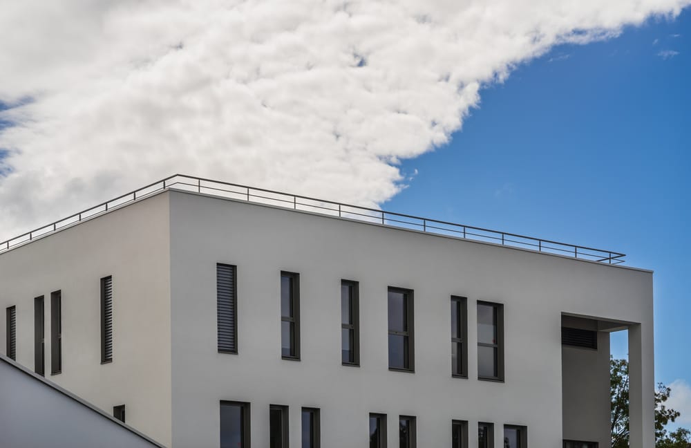 Bâtiment moderne avec toit plat et garde-toit servant de garde-corps en acier